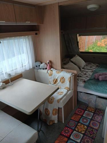 a small room with a table and a couch in a trailer at Pod Wierzba in Dobrzyki