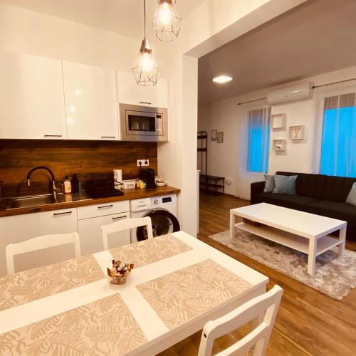 a kitchen and a living room with a table and chairs at Argent apartman in Balatonmáriafürdő