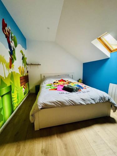 a bedroom with a bed and a blue wall at Quartier Général des Gamers Arcade Terrasse in Saint-Omer