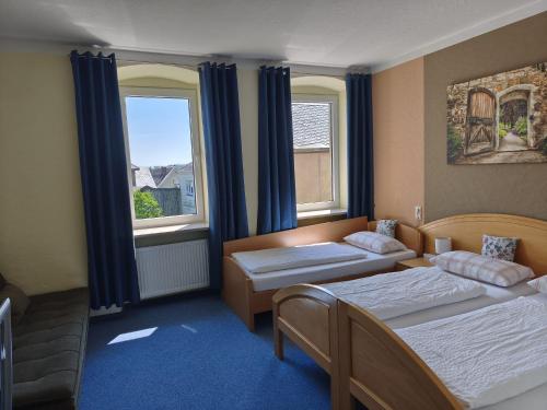 a hotel room with two beds and two windows at Garni Hotel Post in Weißenstadt