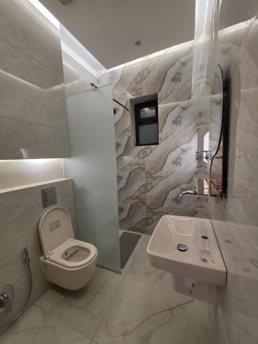 a white bathroom with a toilet and a sink at Ayla Shalet Villa in Al Kufayr