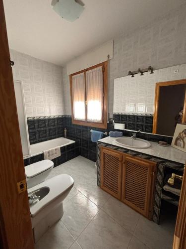 a bathroom with a sink and a toilet and a tub at Los Balcones de San Marcos in Galera