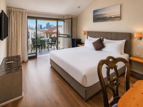 a hotel room with a bed and a balcony at Margosa Boutique Hotel Tel-Aviv Jaffa in Tel Aviv