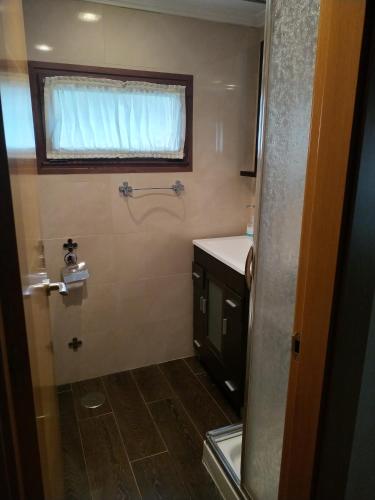 a small bathroom with a sink and a window at Peña Pandos 2 Estrellas in Felechosa