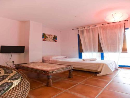 a bedroom with two beds and a table in it at Livingtarifa Ático Altarik in Tarifa
