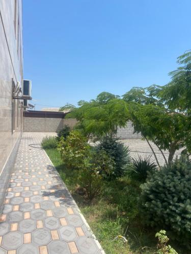 a brick walkway next to a building with a tree at RUBENYAN GUEST HOUSE in Artashat