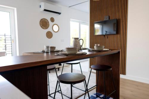a kitchen with a wooden bar with stools at Leiria Design Suites in Leiria