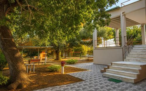 a building with stairs next to a tree at Villa Serena in Mytikas