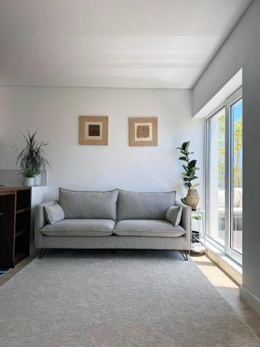 a living room with a couch and a window at Leiria Design Suites in Leiria