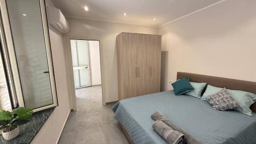 a bedroom with a blue bed and a large window at RaJan Home Blue in Palizzi Marina