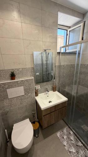 a bathroom with a toilet and a sink and a shower at RaJan Home Blue in Palizzi Marina
