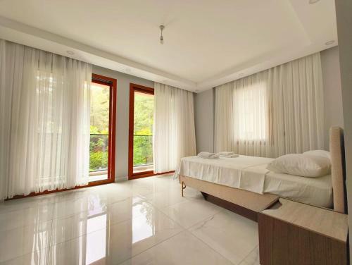 a bedroom with a bed and large windows at Villa Musa in Marmaris