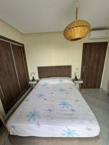 a large bed in a room with two tables at Smir Park apartamento in Marina Smir