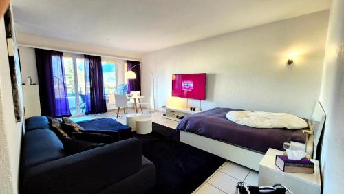 a hotel room with a bed and a couch at Wohnung nr 103 in Muralto