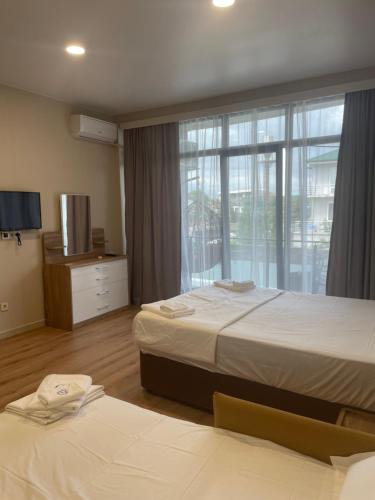 a hotel room with two beds and a window at Hotel Zich in Kobuleti