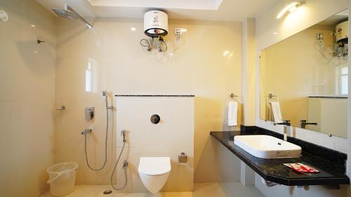 a bathroom with a shower and a toilet and a sink at ROYAL GITANJALI RESORTS & SPA in Mandarmoni