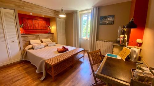 a bedroom with a bed and a table in a room at La Dorépontaise CHAMBRE D'HOTES in Pondaurat