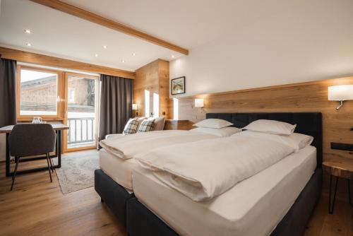 a large bedroom with a large bed and a desk at Jochum Hotel Garni in Fiss