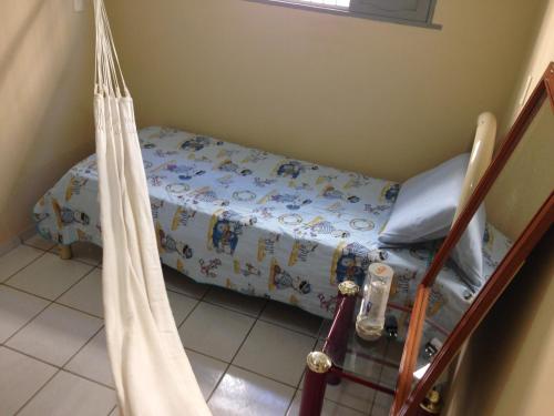 a small bed in a small room with a bedvisor at Casa de Aninha in Natal