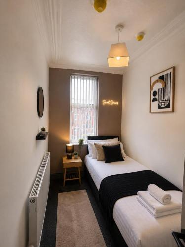 a small bedroom with two beds and a window at 6 BR Home Free Parking Sleeps 14 Table Tennis City Centre Pool Table in Central Station