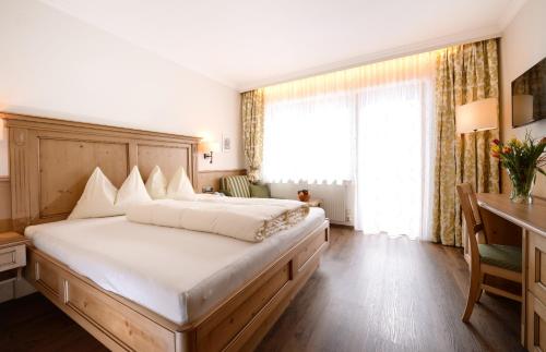 a bedroom with a large bed and a desk at B&B Monte in Kartitsch