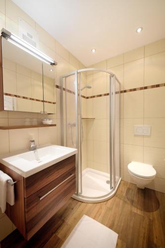 a bathroom with a shower and a sink and a toilet at B&B Monte in Kartitsch