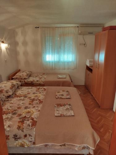 a small bedroom with two beds and a window at MARINOVIC APARTMENTS in Budva