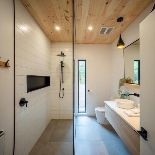 a bathroom with a shower and a toilet and a television at Chalet OSLO in Saint Come