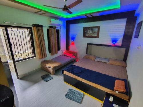 a room with a bed and a couch in it at NIRMAN beach homestay in Puri