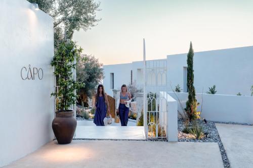 two women walking down a hallway in a building at CAPO LEFKADA Villa 97 - Sea View - Two Private Pools in Tsoukalades