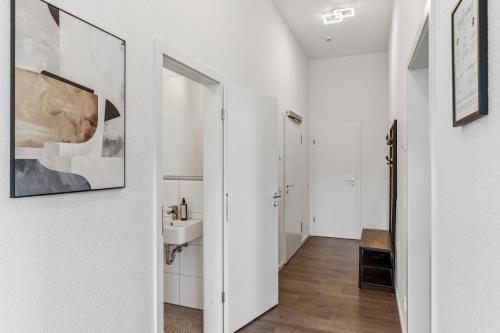 a white bathroom with a sink and a mirror at Cozy Apartment Central Kitchen Balcony in Frechen