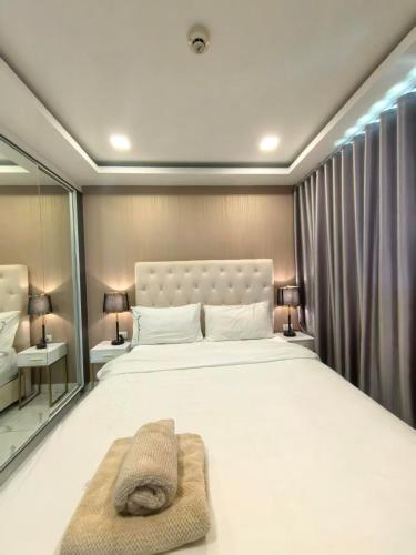 a bedroom with a large white bed and a mirror at 千禧大厦 in Pattaya South