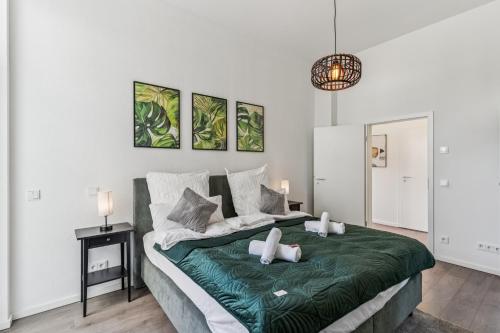 a bedroom with a large bed with a green blanket at Cozy Apartment Central Kitchen Balcony in Frechen