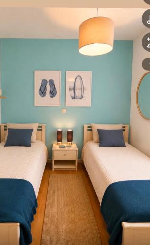 two beds in a room with blue walls at Apartment Aleks in Tar