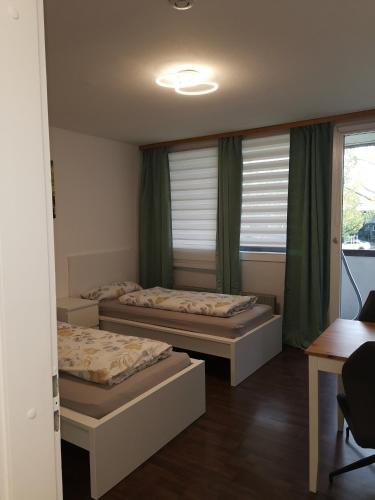 two beds in a room with a window at Monteurwohnung Hoffmann in Heilbronn