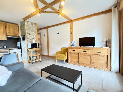 a living room with a couch and a tv at Apparement cosy 4 personnes in Samoëns