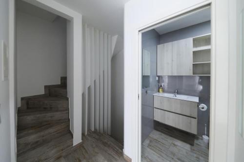 a kitchen with white cabinets and a sink at Apartamentos e quartos Primorosa in Nazaré
