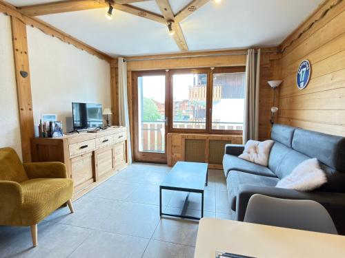 a living room with a couch and a tv at Apparement cosy 4 personnes in Samoëns