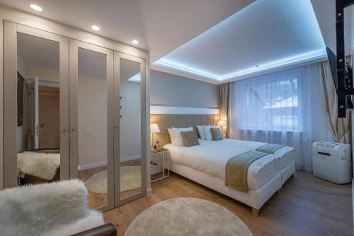 sypialnia z łóżkiem i dużym oknem w obiekcie Hills Park Luxury Apartment w Wilnie