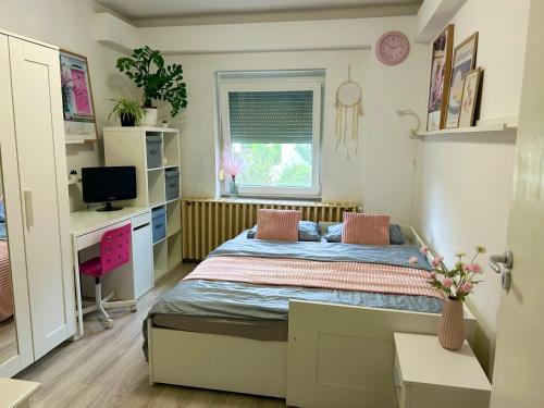 a small bedroom with a bed and a desk at Gabi Apartman in Gyenesdiás