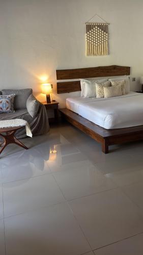a bedroom with two beds and a couch in it at Alaksa villa padang padang 6 in Bingin Beach