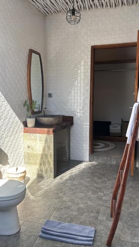 a bathroom with a sink and a toilet and a mirror at Alaksa villa padang padang 6 in Bingin Beach
