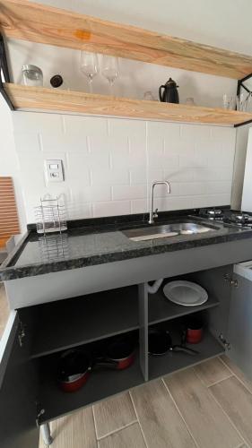 a kitchen with a sink and a counter top at Studio no Centro com VISTA PARA O CRISTO in Poços de Caldas