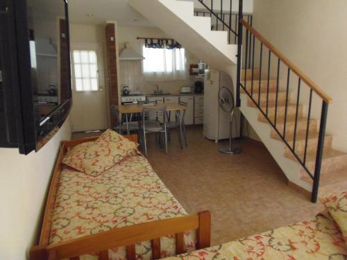 a room with a bed and a kitchen and a staircase at Complejo Andalhue in Puerto Madryn