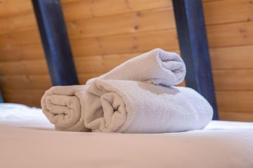 a pile of towels sitting on a bed at Golden Cabins Gjinar by PikHost in Elbasan