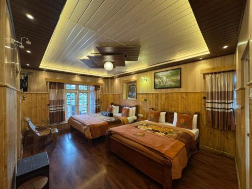 a bedroom with two beds and a ceiling at Himawari Hills Hotel and Hostel in Nuwara Eliya