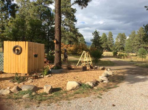 a wooden out house next to a tree at Elktrace Bed and Breakfast in Pagosa Springs