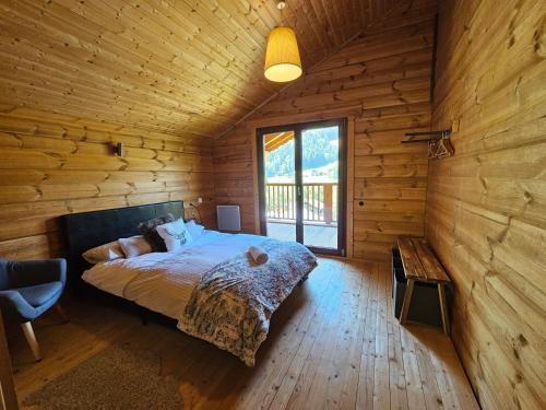 a bedroom with a bed in a wooden cabin at Chalet Etoile in Abondance