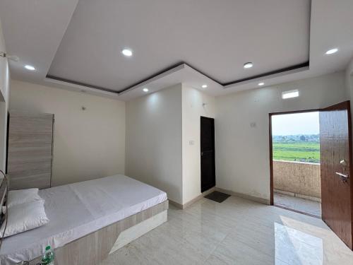 a bedroom with a bed and a large window at Yashoda Inn in Ormānjhi