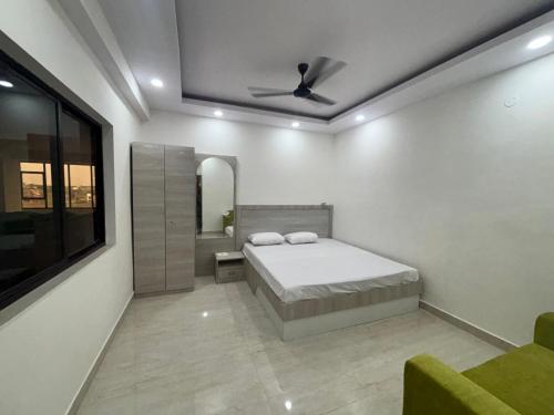 a bedroom with a bed and a ceiling fan at Yashoda Inn in Ormānjhi